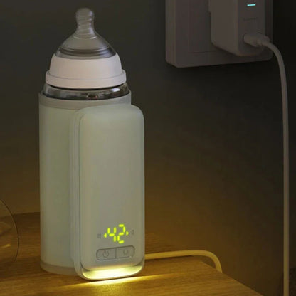 Chauffe-biberon portable vert en charge posé sur une table