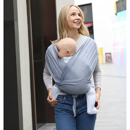 Echarpe porte bebe gris clair maman souriante dans  la rue avec son bebe