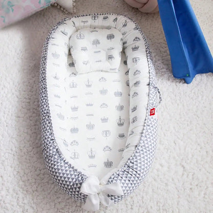 Nid bébé couronne  gris  posé sur un tapis