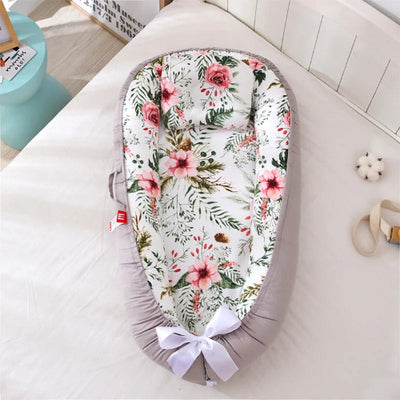 Nid bébé floral bien posé sur un lit
