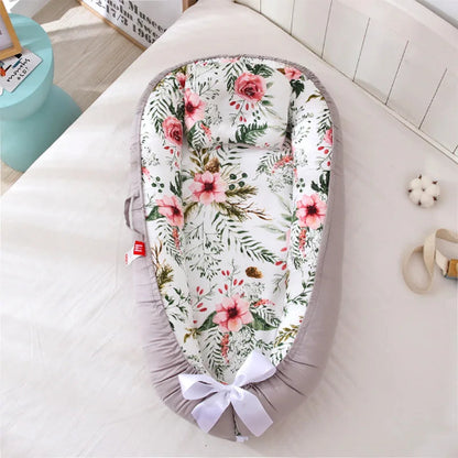 Nid bébé floral bien posé sur un lit
