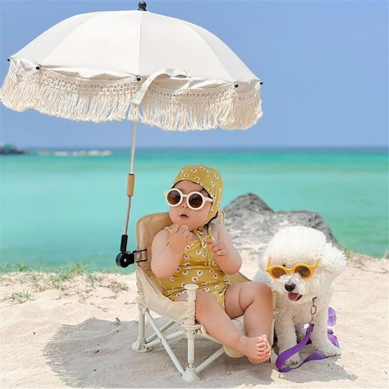 Ombrelle pour poussette Type A l'enfant assis dans sa chaise à la plage avec son chien.