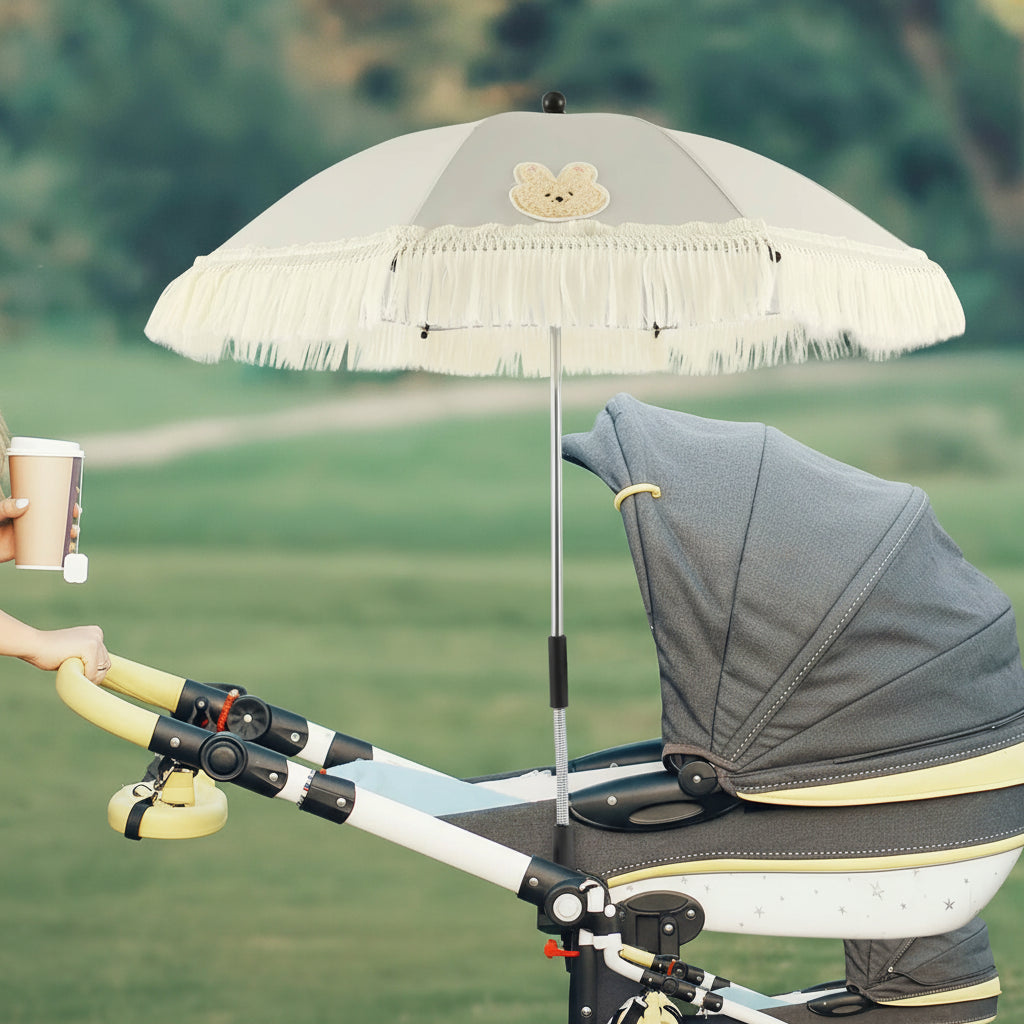 Ombrelle poussette blanc, maman avec son café en main transporte son enfant