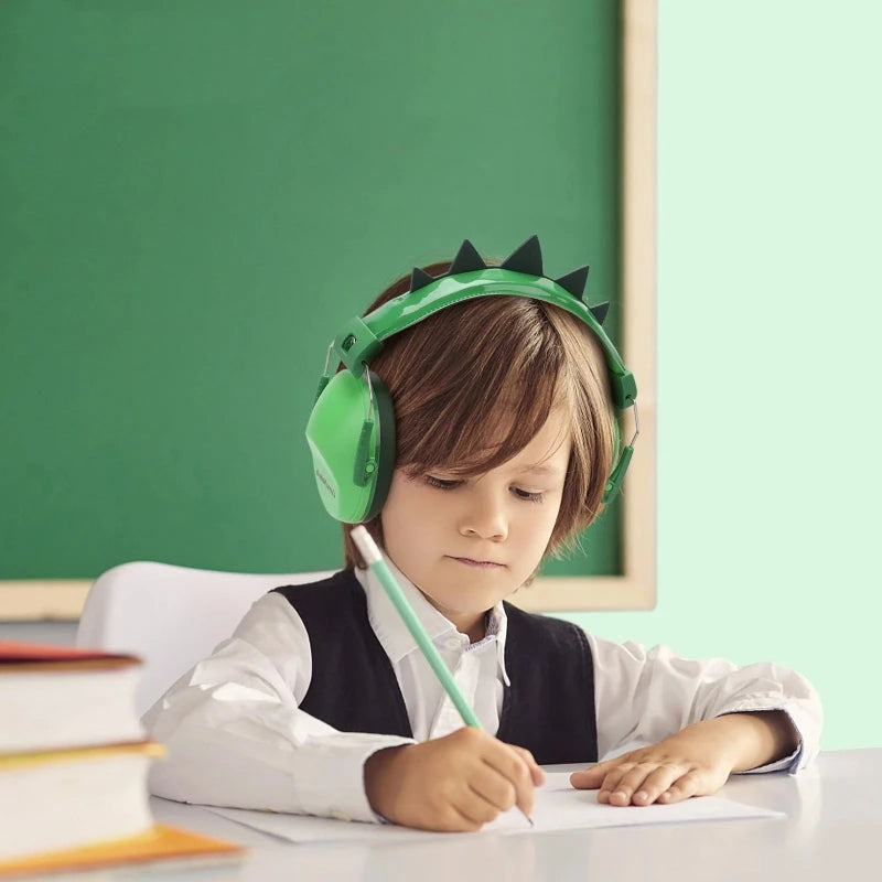 casque anti bruit enfant  vert le jeune garcon dans sa classe en train d' écrire