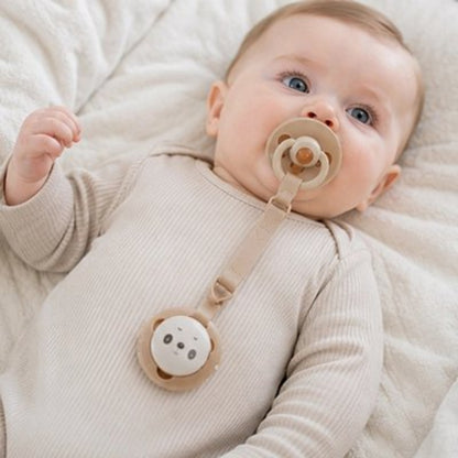 Attache tetine beige bébé couché dans son lit 