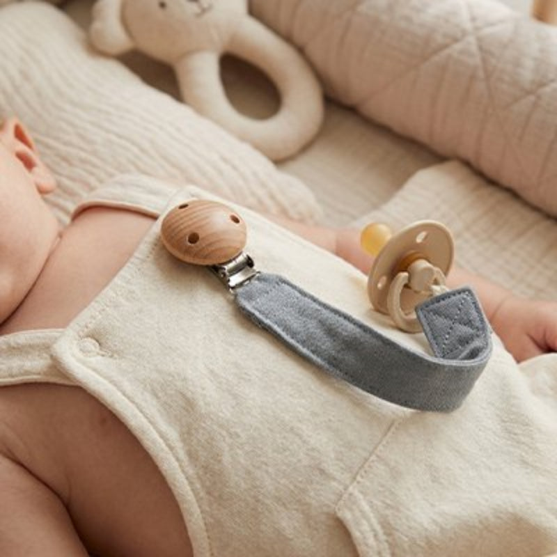 Attache tetine bleu, bébé qui s'endort dans son lit