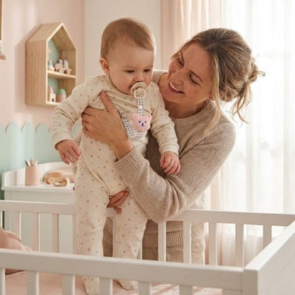 Attache tetine rose maman qui met son enfant dans son lit