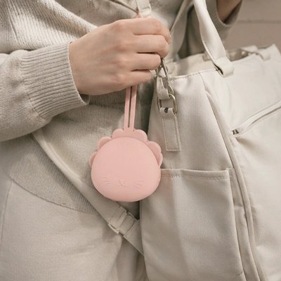 Boite a tetine​ bebe rose accroché sur le sac 