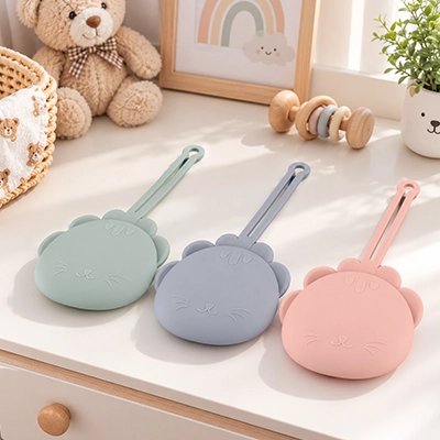 Boite a tetine​ bebe vert, gris et rose posées sur la table