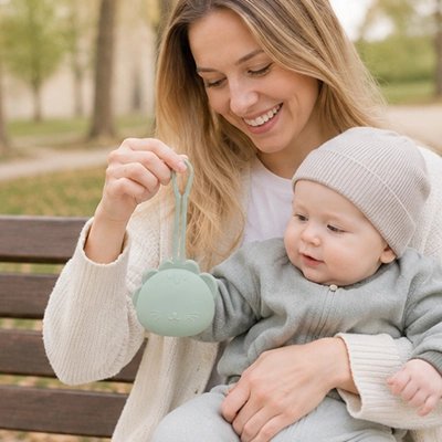 Boite a tetine​ bebe vert maman et son bébé assis sur un banc