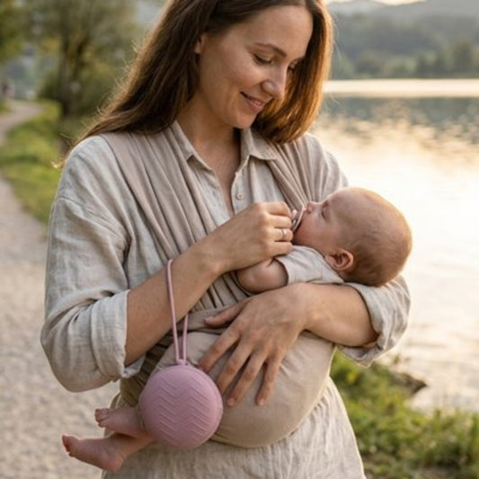 Boite a tetine mauve maman met la tétine dans la bouche de son bébé
