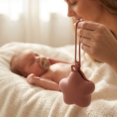 Boite a tetine rose bébé dors avec sa tétine dans la bouche