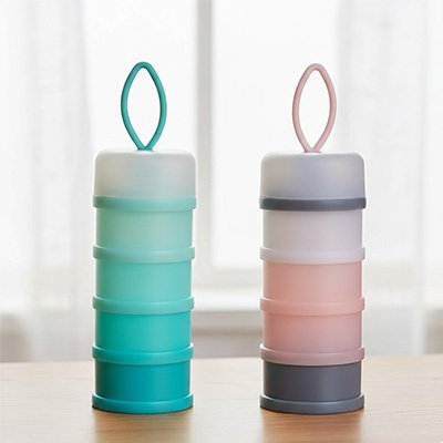 Boite doseuse lait  rose et bleu posées sur la table