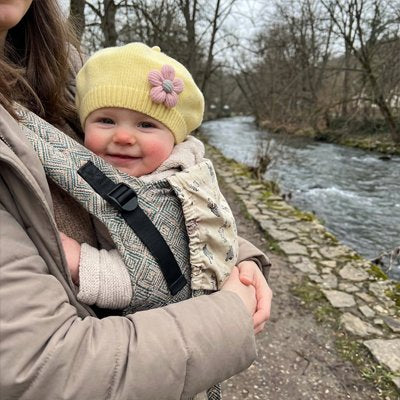 Bonnet bébé fille jaune, bébé qui regarde en avant en souriant