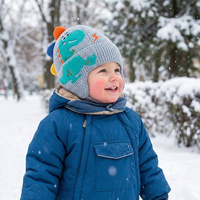 Bonnet bébé garçon bleu clair bébé tout souriant dans la neige