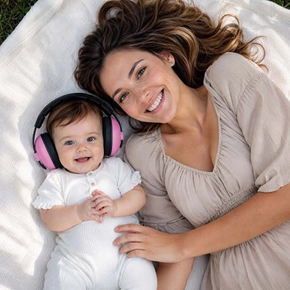 Casque anti bruit bebe rose maman et son enfant tous souriant couchés sur le lit 