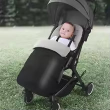 chancelière pour poussette gris clair bébé bien confortable sur le gazon dans sa poussette