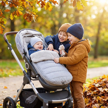 chanceliere poussette bebe gris, bébé dans sa poussette joue avec ses frères en automne