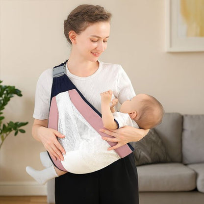 Echarpe de portage rose maman qui porte bébé horizontalement au salon