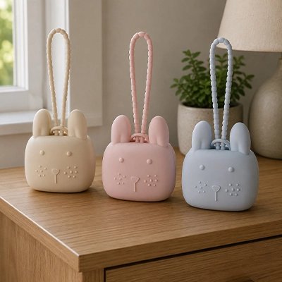 La boite a tetine​ beige, rose et bleu posées sur la table