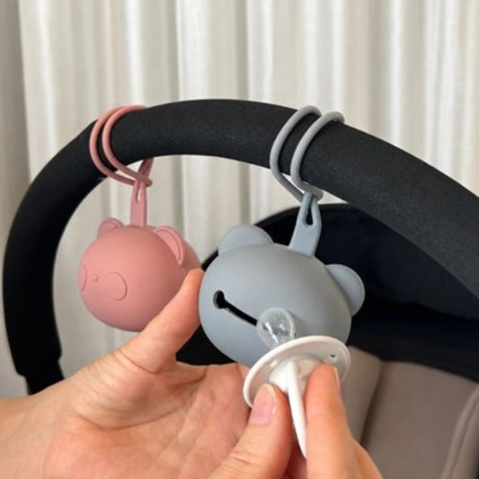  la boite a tetine​ rose et bleu attachées sur la poussette