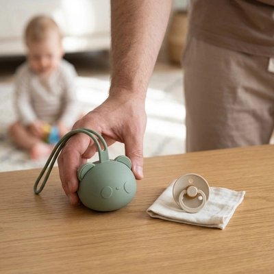 La boite a tetine​ vert papa depose la boite près de la tétine