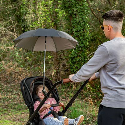 Ombrelle pour poussette​ gris papa qui promèdne son enfant 