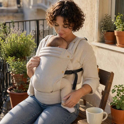 Porte bebe beige bébé qui dort confortablement contre sa maman