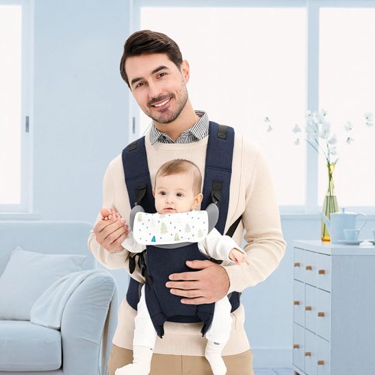 Porte bébé bleu, papa tout souriant porte son bébé vers l'avant
