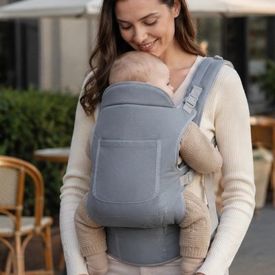 Porte bébé gris, bébé qui est confortable contre sa maman