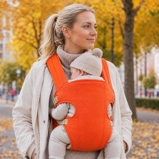 Porte bebe orange maman qui porte son enfant les mains libres dans les poches