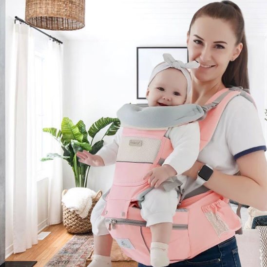 Porte bebe rose, bébé tout souriant assis face à l'avant 
