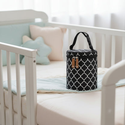porte biberon noir posé sur le lit de bébé