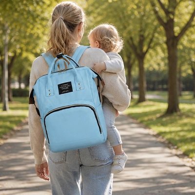 Sac a dos a langer bleu, maman portant son fils et son sac au dos