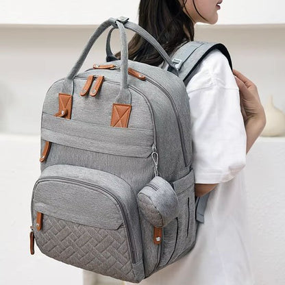 Sac à dos à  langer gris au dos de maman