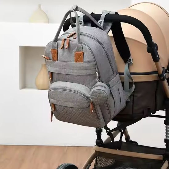 Sac à dos à langer gris sur une poussette au salon