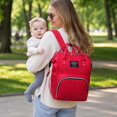 Sac a dos a langer rose, maman qui se promène avec son sac au dos et bébé à main