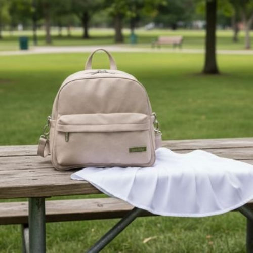 Sac a langer a dos beige posé sur la table