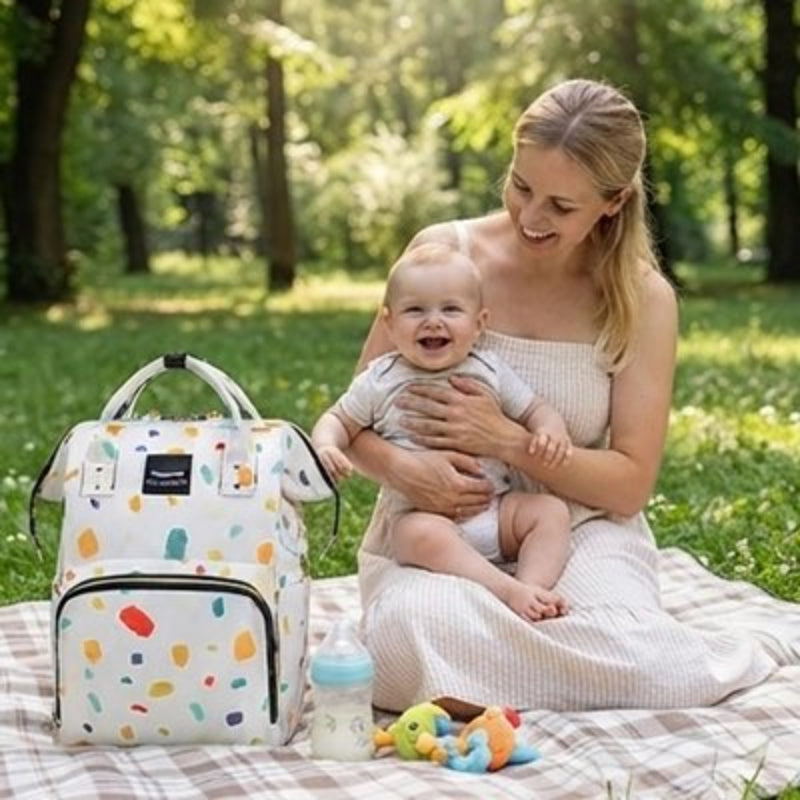 Sac a langer bebe blanc assise au parc avec son enfant bien souriant