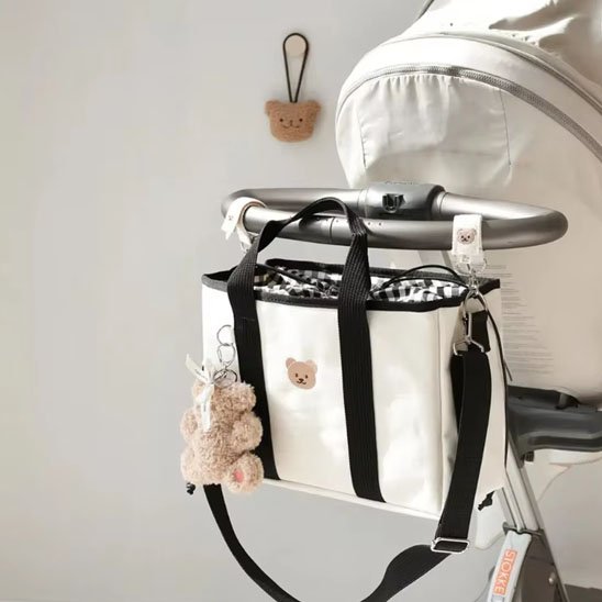 Sac à langer blanc noir accroché sur une poussette