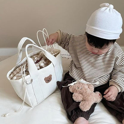 Sac à langer  blanc posé à coté du bébé