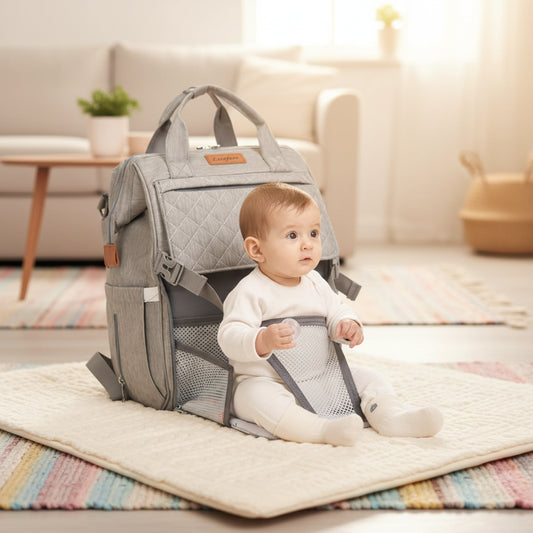 sac à langer sac à dos gris , bebe bien assis sur le tapis au salon