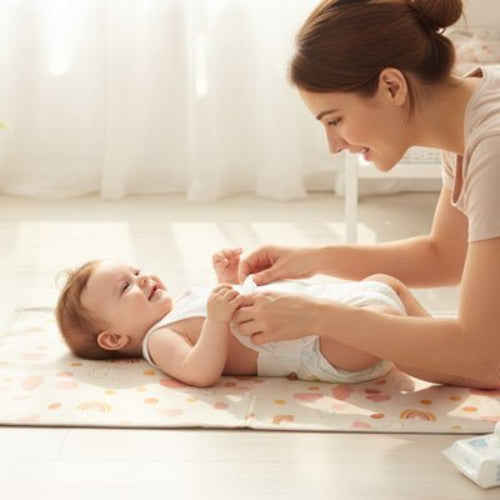 Tapis à langer nomade  arc- en -ciel maman qui habille bébé 