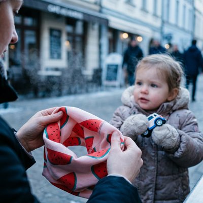 Tour de cou bebe fille maman qui s'apprete à enfiler l'echarpe de son enfant