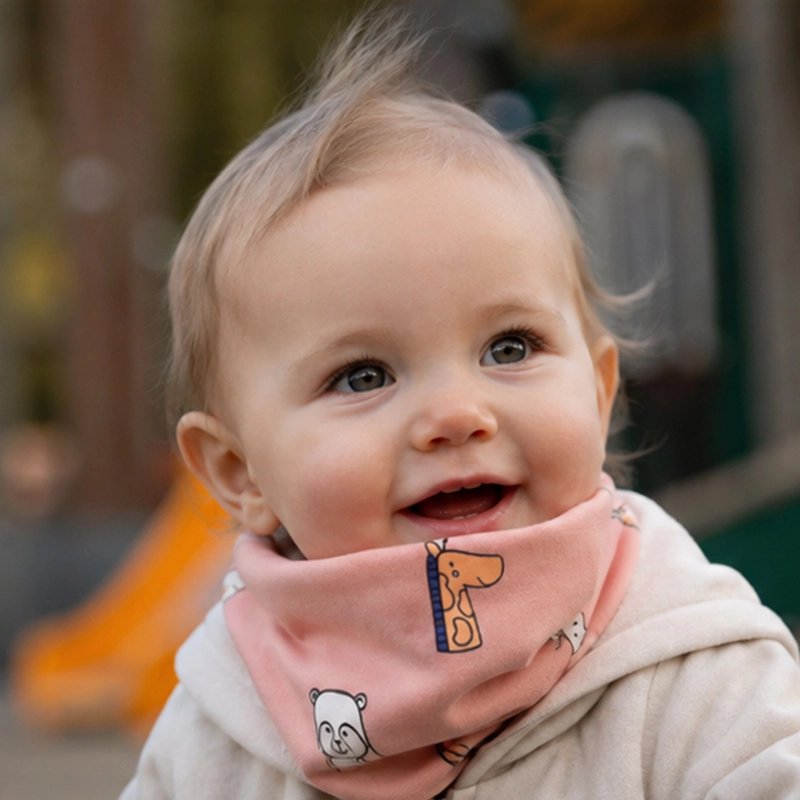 Tour de cou bebe rose, bébé sourit face à la caméra
