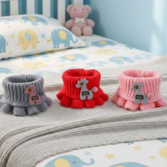 Tour de cou enfant  gris, rouge .rose  posés sur le lit