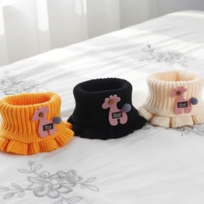 Tour de cou enfant  jaune, noir et beige posés sur la table  